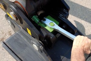 Man using wrench to work on a Geith attachment